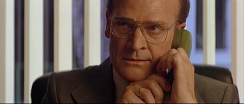 Movie still from “Bad Education” (2004), directed by Pedro Almodóvar – A man in a suit and glasses is talking on a phone; Close Up shot, Low angle