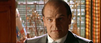 Movie still from “Bad Education” (2004), directed by Pedro Almodóvar – A man in a suit and tie looking at the camera; Close Up shot, Low angle