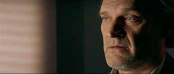 Movie still from “Bad Education” (2004), directed by Pedro Almodóvar – A man's face in a dark room; Close Up shot, Low angle