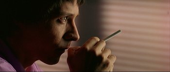 Movie still from “Bad Education” (2004), directed by Pedro Almodóvar – A person holding a cigarette in his mouth; Extreme Close Up shot, Over the shoulder angle