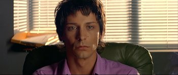 Movie still from “Bad Education” (2004), directed by Pedro Almodóvar – A person wearing a purple shirt; Close Up shot, Low angle