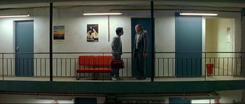 Movie still from “Bad Education” (2004), directed by Pedro Almodóvar – Two men standing next to each other on a balcony; Wide shot, Low angle