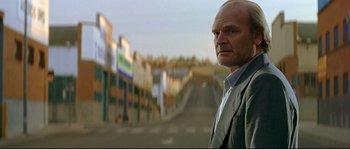 Movie still from “Bad Education” (2004), directed by Pedro Almodóvar – A man standing in the middle of a street; Medium shot, Low angle
