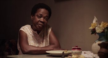A woman sitting at a table with a plate of food in front of her