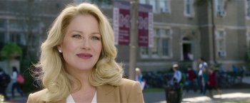 A woman with blonde hair and a brown jacket