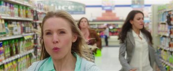 Movie still from “Bad Moms” (2016), directed by Scott Moore – A woman blowing a kiss while standing in front of a store; Close Up shot, Over the shoulder angle