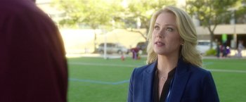 Movie still from “Bad Moms” (2016), directed by Scott Moore – A woman standing in front of a soccer field; Close Up shot, Over the shoulder angle