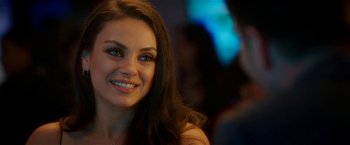 Movie still from “Bad Moms” (2016), directed by Scott Moore – A beautiful young lady smiling at the camera while sitting at a table; Close Up shot, Over the shoulder angle