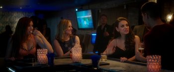 Movie still from “Bad Moms” (2016), directed by Scott Moore – A group of people sitting at a table in front of a tv; Medium shot, Over the shoulder angle