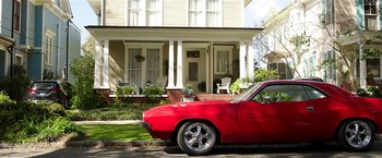 Movie still from “Bad Moms” (2016), directed by Scott Moore – A red car parked in front of a white house; Wide shot, Low angle