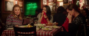 Movie still from “Bad Moms” (2016), directed by Scott Moore – A woman sitting at a table with plates of food; Medium shot, Over the shoulder angle