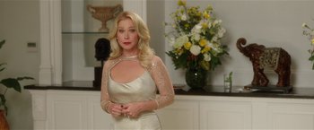 Movie still from “Bad Moms” (2016), directed by Scott Moore – A woman standing in front of a vase of flowers; Medium shot, Over the shoulder angle