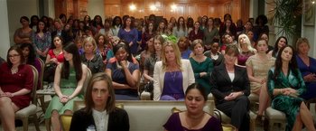 Movie still from “Bad Moms” (2016), directed by Scott Moore – A group of people sitting in a room with their hands on their hips; Wide shot, High angle