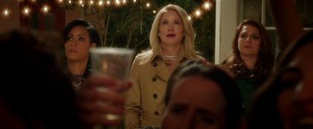 Movie still from “Bad Moms” (2016), directed by Scott Moore – A woman in a trench coat holding a glass of wine; Close Up shot, Over the shoulder angle