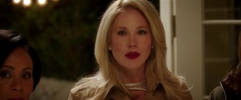 Movie still from “Bad Moms” (2016), directed by Scott Moore – A woman with blonde hair wearing a trench coat and red lipstick; Close Up shot, Over the shoulder angle