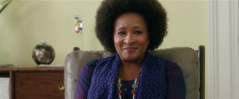 Movie still from “Bad Moms” (2016), directed by Scott Moore – An older woman sitting on a couch wearing a blue scarf; Close Up shot, Over the shoulder angle