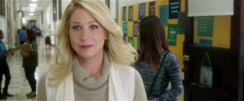 Movie still from “Bad Moms” (2016), directed by Scott Moore – A woman with blonde hair is smiling for the camera; Close Up shot, Over the shoulder angle