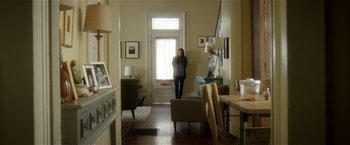 Movie still from “Bad Moms” (2016), directed by Scott Moore – A woman standing in front of a door in a room; Wide shot, Low angle
