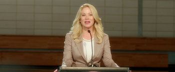 Movie still from “Bad Moms” (2016), directed by Scott Moore – A woman is giving a speech at a podium; Close Up shot, Low angle
