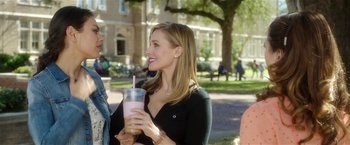 Movie still from “Bad Moms” (2016), directed by Scott Moore – A woman is holding a drink and smiling for the camera; Medium shot, Over the shoulder angle