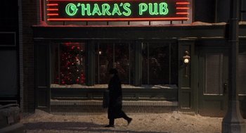 Movie still from “Bad Santa” (2003), directed by Terry Zwigoff – A person walking in front of o ' hara's pub; Wide shot, Low angle