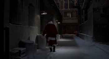 Movie still from “Bad Santa” (2003), directed by Terry Zwigoff – A man dressed as santa claus walking down a snowy street; Extreme Wide shot, High angle