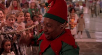 Movie still from “Bad Santa” (2003), directed by Terry Zwigoff – A man dressed as a christmas elf in front of a group of children; Close Up shot, Over the shoulder angle