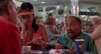 Movie still from “Bad Santa” (2003), directed by Terry Zwigoff – A man and a woman sitting at a table with chopsticks in their hands; Medium shot, Over the shoulder angle