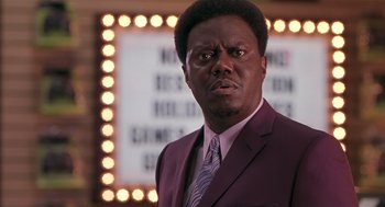 Movie still from “Bad Santa” (2003), directed by Terry Zwigoff – A man wearing a suit and tie standing in front of a mirror; Close Up shot, Low angle