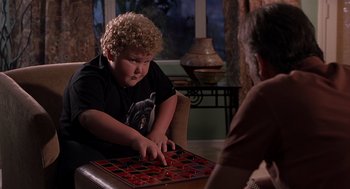 Movie still from “Bad Santa” (2003), directed by Terry Zwigoff – A young boy is playing a game with his mother; Medium shot, High angle