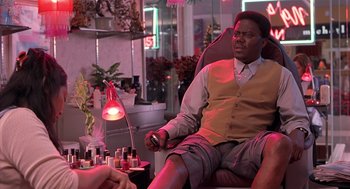 Movie still from “Bad Santa” (2003), directed by Terry Zwigoff – A man sitting in a chair in front of a woman; Medium shot, High angle