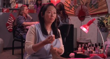 Movie still from “Bad Santa” (2003), directed by Terry Zwigoff – A woman sitting at a table with her hands clasped together; Close Up shot, High angle