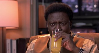 Movie still from “Bad Santa” (2003), directed by Terry Zwigoff – A man is drinking a glass of orange juice; Close Up shot, High angle