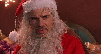 Movie still from “Bad Santa” (2003), directed by Terry Zwigoff – A person wearing a santa claus costume; Close Up shot, Over the shoulder angle