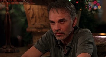 Movie still from “Bad Santa” (2003), directed by Terry Zwigoff – A person sitting at a table; Close Up shot, Over the shoulder angle