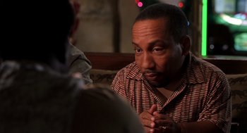 Movie still from “Bad Santa” (2003), directed by Terry Zwigoff – A man sitting in front of another man in front of a christmas tree; Close Up shot, Over the shoulder angle