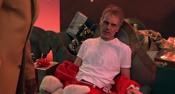 Movie still from “Bad Santa” (2003), directed by Terry Zwigoff – A man sitting in a chair wearing a santa clause outfit; Close Up shot, Low angle