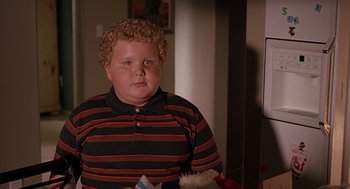 Movie still from “Bad Santa” (2003), directed by Terry Zwigoff – A boy with curly blonde hair wearing a striped shirt; Close Up shot, High angle
