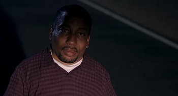 Movie still from “Bad Santa” (2003), directed by Terry Zwigoff – A man in a purple shirt is standing in the dark; Close Up shot, Low angle