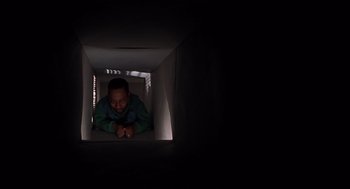 Movie still from “Bad Santa” (2003), directed by Terry Zwigoff – A man laying on the ground inside a box; Close Up shot, Low angle