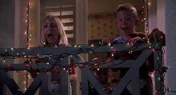 Movie still from “Bad Santa” (2003), directed by Terry Zwigoff – A group of kids standing next to each other with christmas lights; Medium shot, Low angle