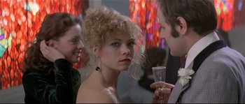 Movie still from “Bad Timing: A Sensual Obsession” (1980), directed by Nicolas Roeg – A woman in a strapless dress holding a wine glass; Close Up shot, Over the shoulder angle