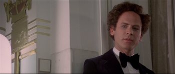 Movie still from “Bad Timing: A Sensual Obsession” (1980), directed by Nicolas Roeg – A man in a suit and bow tie; Close Up shot, Over the shoulder angle