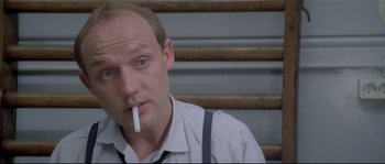 Movie still from “Bad Timing: A Sensual Obsession” (1980), directed by Nicolas Roeg – A man smoking a cigarette while sitting on a bench; Close Up shot, High angle