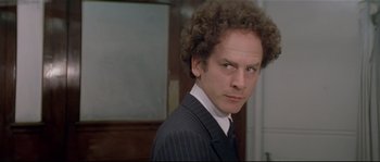 Movie still from “Bad Timing: A Sensual Obsession” (1980), directed by Nicolas Roeg – A man in a suit and tie standing in front of a mirror; Close Up shot, Over the shoulder angle