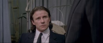 Movie still from “Bad Timing: A Sensual Obsession” (1980), directed by Nicolas Roeg – A person wearing a suit and tie; Close Up shot, Over the shoulder angle