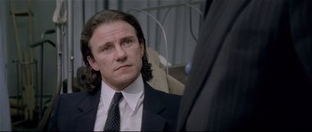 Movie still from “Bad Timing: A Sensual Obsession” (1980), directed by Nicolas Roeg – A man in a suit and tie looking to his left; Close Up shot, Over the shoulder angle