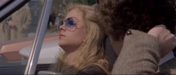 Movie still from “Bad Timing: A Sensual Obsession” (1980), directed by Nicolas Roeg – A woman wearing sunglasses sitting next to a man; Close Up shot, Over the shoulder angle