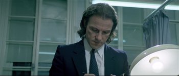 Movie still from “Bad Timing: A Sensual Obsession” (1980), directed by Nicolas Roeg – A man in a suit writing on a piece of paper; Close Up shot, Low angle