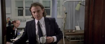 Movie still from “Bad Timing: A Sensual Obsession” (1980), directed by Nicolas Roeg – A man in a suit holding a coffee cup; Medium shot, Low angle